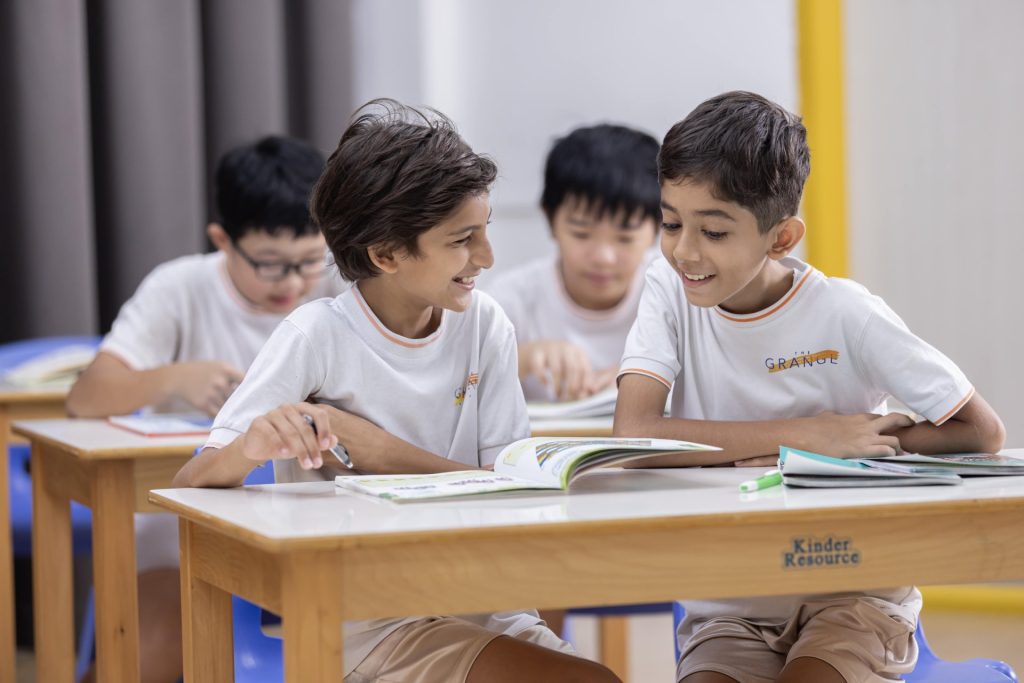 International primary school students learning together with textbooks